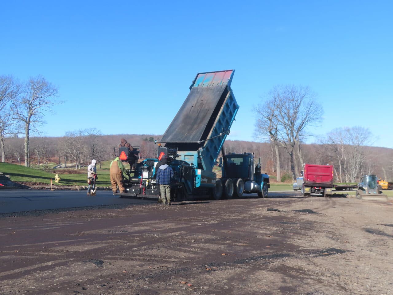 Golf Course Paving project in New Haven, CT — paver and dump truck on prepped lot