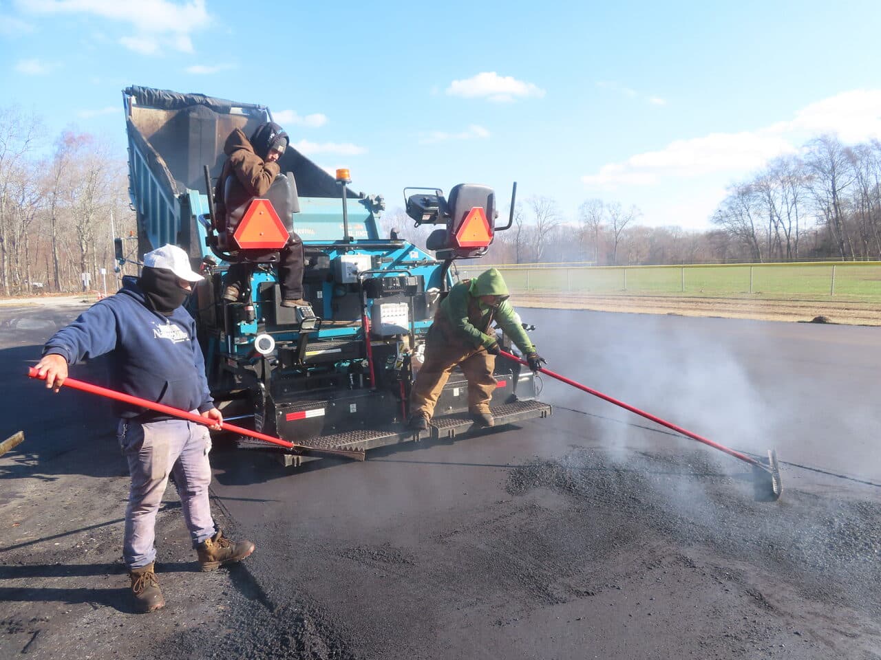 Commercial Parking Lot Paving project in Montville, CT — workers smoothing fresh asphalt