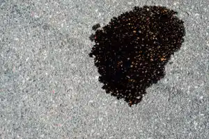 Oil puddle leak on asphalt driveway