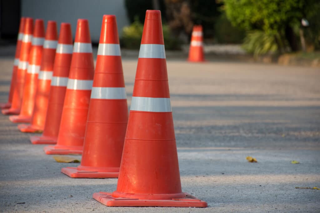 Traffic cones placed on a commercial parking lot to guide traffic during an asphalt paving project