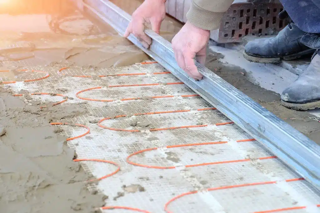 Electric heating cables being installed in a concrete driveway during radiant snow-melt system construction.