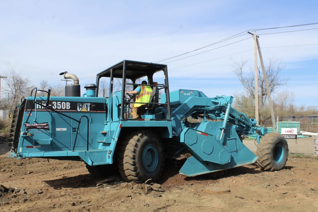 Regrading uneven subgrade to correct low spots before asphalt paving
